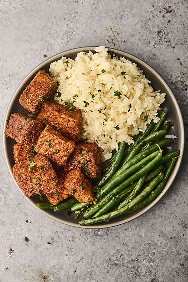 plate of salmon bites with rice and green beans